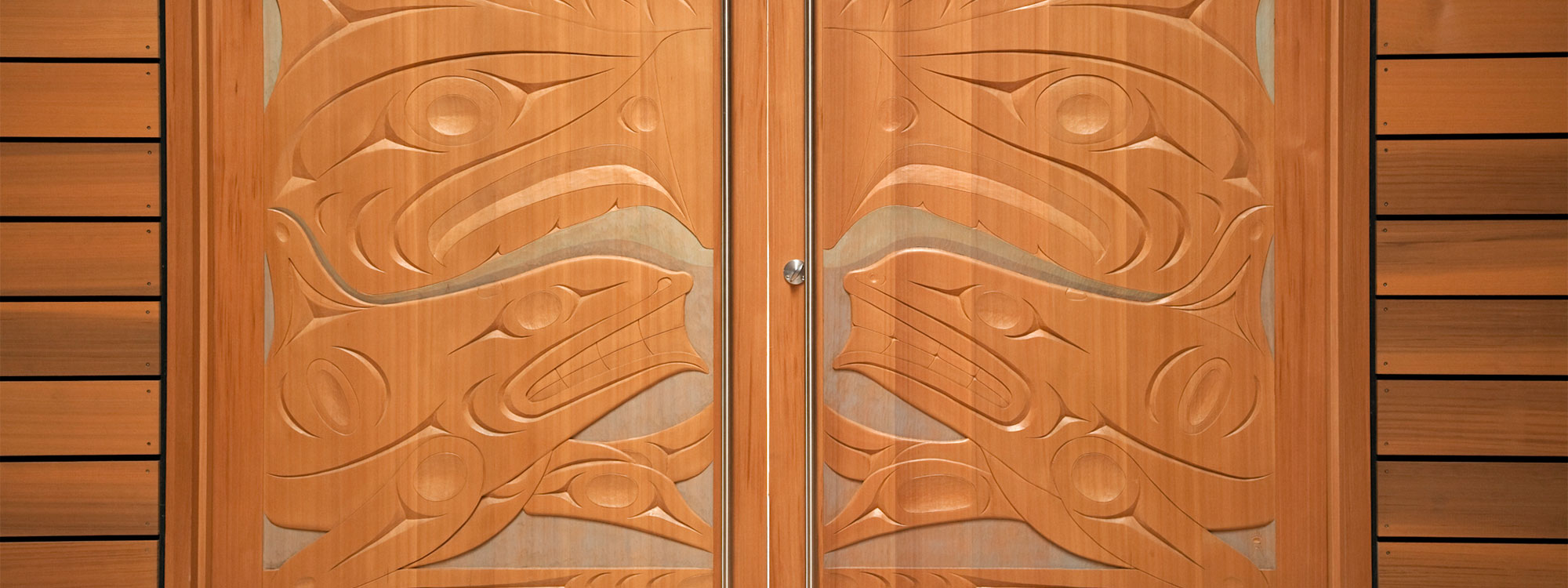 Xwa Lack Tun’s (Rick Harry) carved doors to the Ceremonial Hall in the First Peoples House at the University of Victoria.